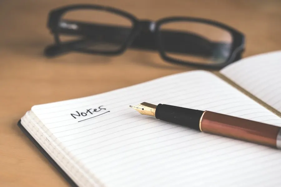 An open notebook headed "Notes" with a fountain pen resting on it and a pair of glasses behind