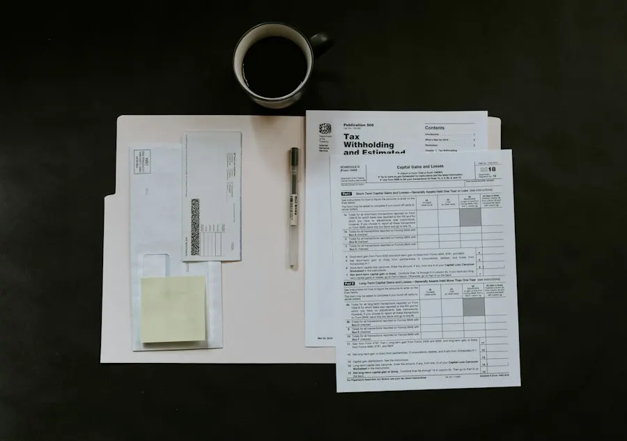Overhead view of paperwork, envelopes, a sticky note and a pen laid out on a folder beside a cup of black coffee